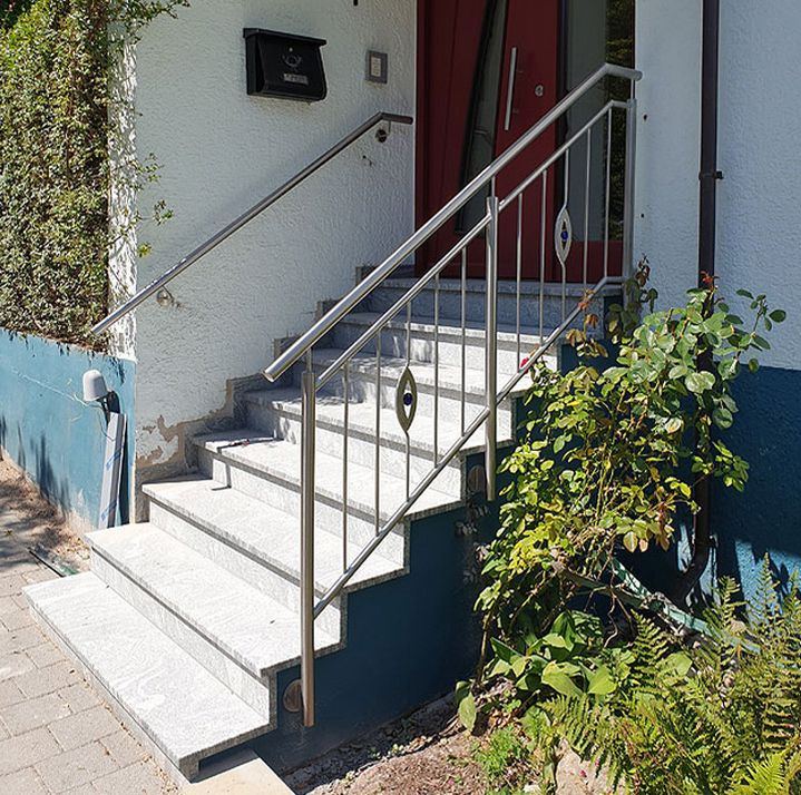 Modernes Edelstahl-Treppengeländer mit dekorativen Glaseinsätzen an einer Außentreppe, gefertigt von Creativ-Metallbau-Tamm.